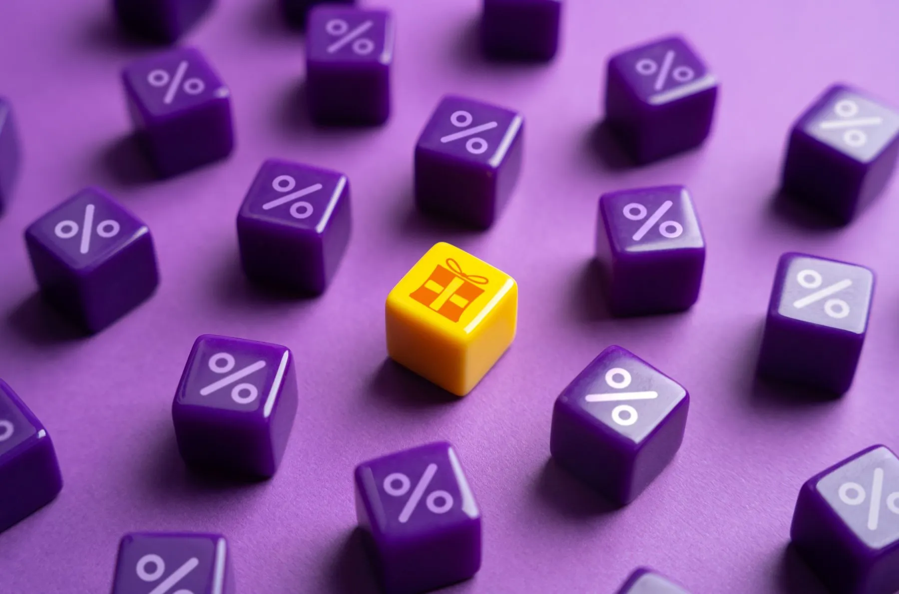 Über ein Dutzend Lila-Spielsteine mit Prozent-Zeichen und in der Mitte ein gelber Spielstein mit einem Geschenk-Zeichen