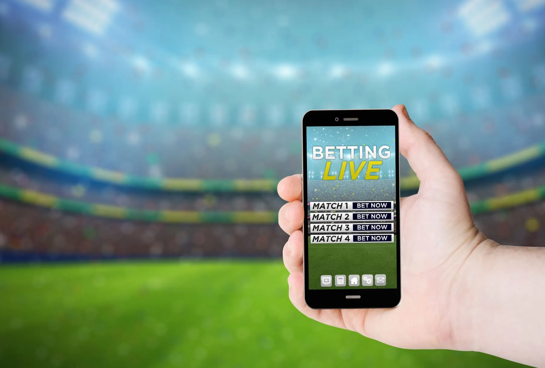 Foto von einer Hand im Stadion, die ein Smartphon mit einer Fußball Wetten App hält