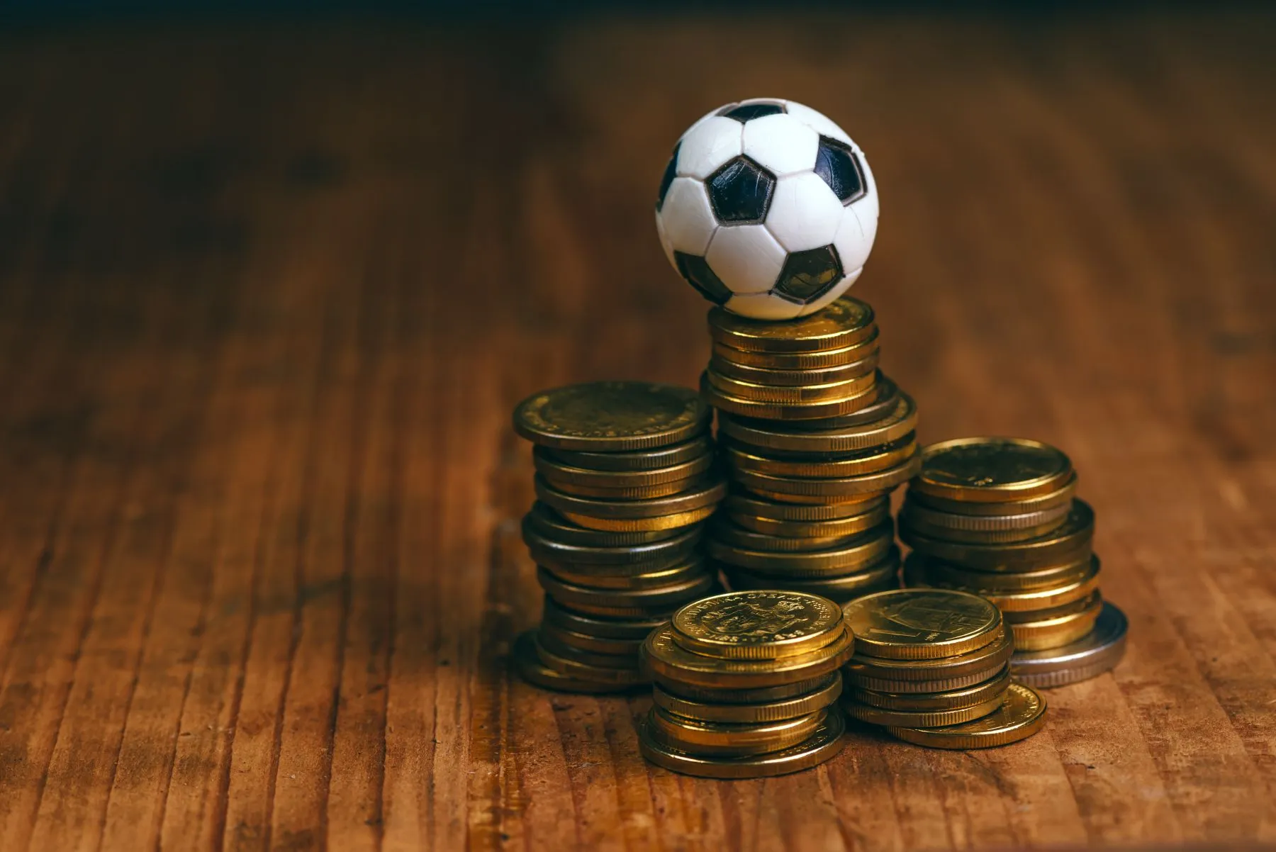 Fußball ist neben mehreren Münzstapeln und befindet sich auf dem höchsten Münzstapel
